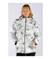 A woman wearing an insulated puffer jacket with light grey with black abstract pattern, featuring a hood, zip closure, and designed for winter wear.