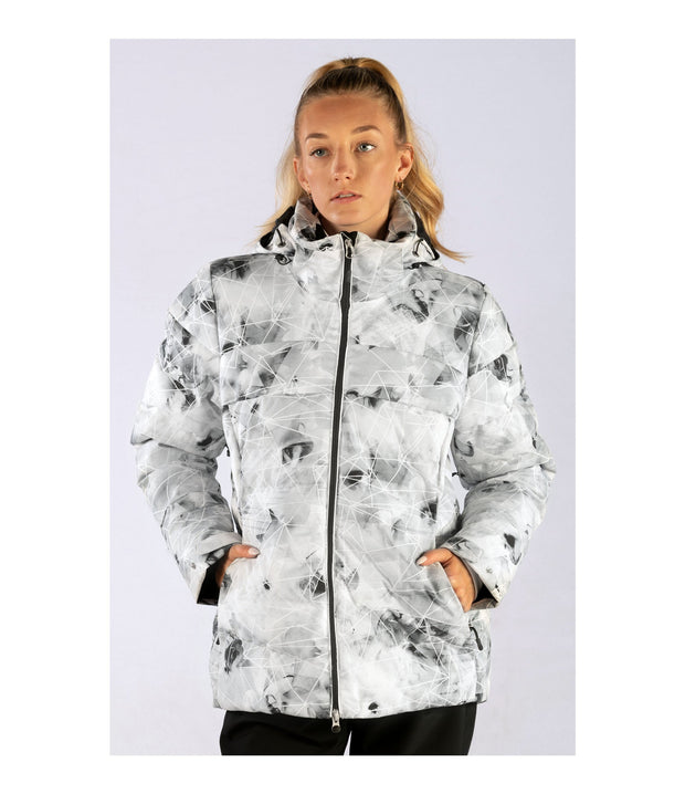 A woman wearing an insulated puffer jacket with light grey with black abstract pattern, featuring a hood, zip closure, and designed for winter wear.