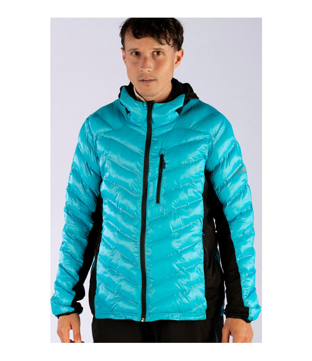 A man wearing a blue light puffer vest featuring a front zip closure, zippered chest pocket, and two side zip pockets, with softstretch side panels.