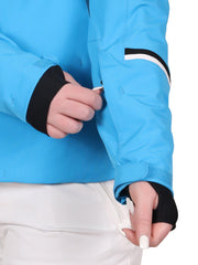 Showing the pocket on the sleeve of a woman wearing a blue insulated jacket with a hood, featuring white and black accents with zippered pockets.
